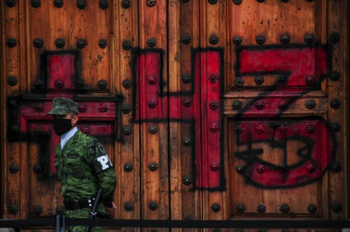 Manifestantes pintaron el número 43 en la Puerta Mariana de Palacio Nacional.