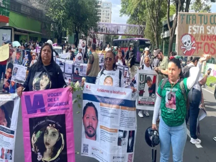Madres buscadoras con fotografías de sus desaparecidos marchan hacia el Estadio Azteca