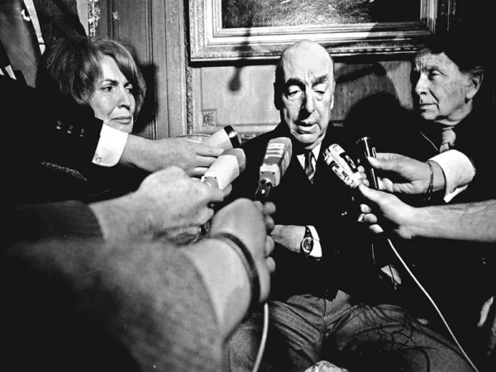 Pablo Neruda sentado en su escritorio, rodeado de libros y papeles, simbolizando su legado y obra