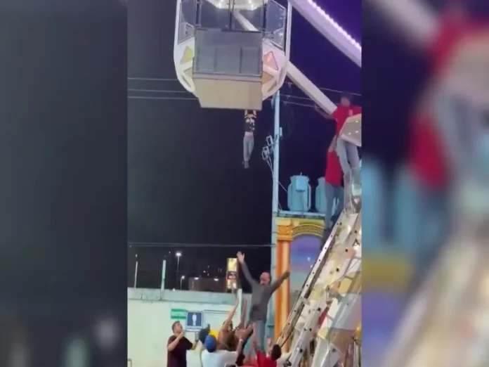 Rescate del niño suspendido feria en la rueda de la fortuna Niño suspendido feria colgando de la rueda de la fortuna en la feria de Torreón